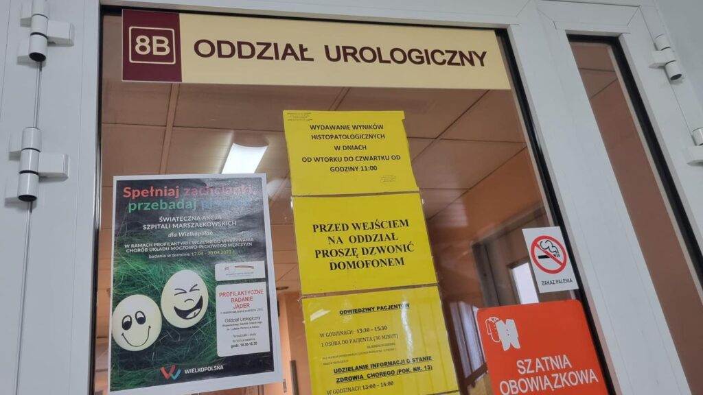 Wejście na Oddział Urologiczny i plakat informujący o prowadzonej przez placówkę akcji profilaktycznej, dotyczącej badania jąder.