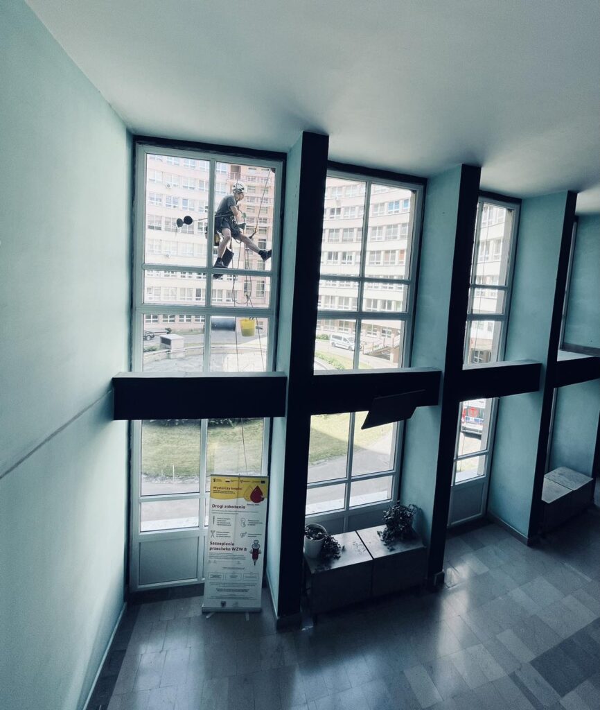 Mycie okien w kaliskim szpitalu przy użyciu sprzętu alpinistycznego.