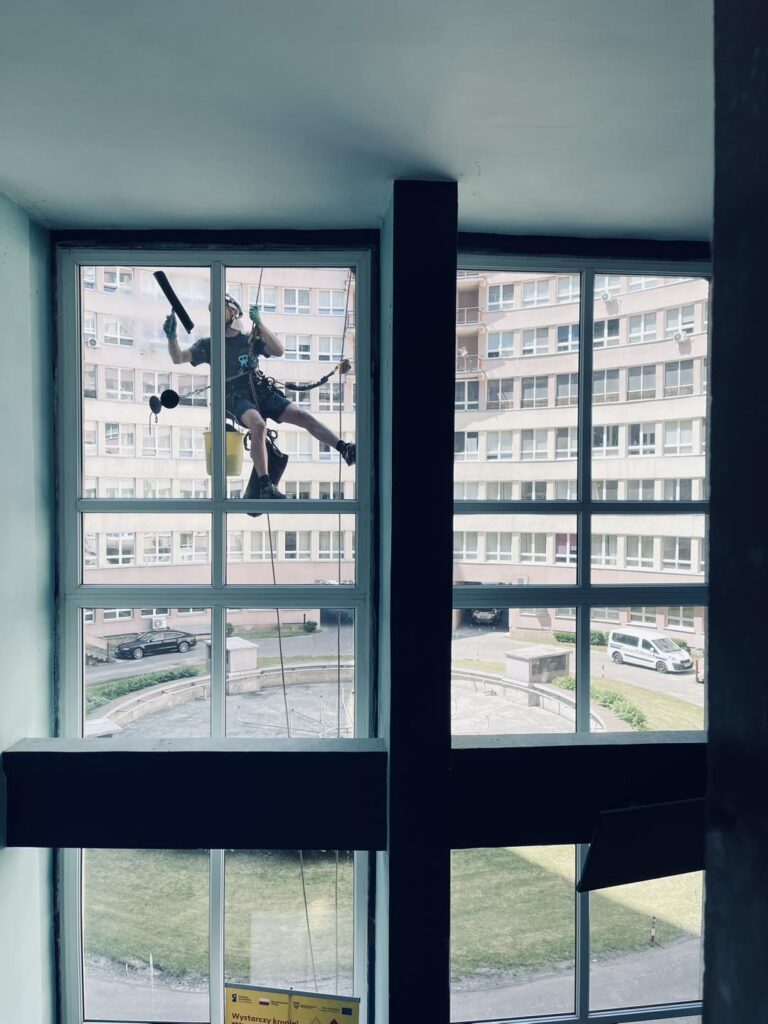 Mycie okien w kaliskim szpitalu przy użyciu sprzętu alpinistycznego.