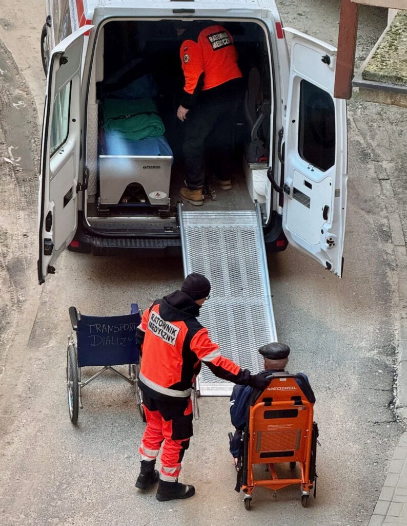 karetka transportowa, dwóch ratowników i pacjent 